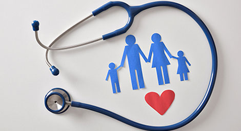 A paper cut out of a family and a heart surrounded by a stethoscope